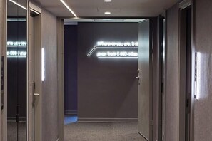 A hallway with a modern light fixture, a door, and a carpeted floor. - Hub Hotel Ximen-Kunming Branch (Taipei)