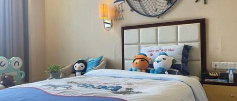 Quarto de hotel com cama, mesa de cabeceira, relógio de parede e um ornamento decorativo na parede.