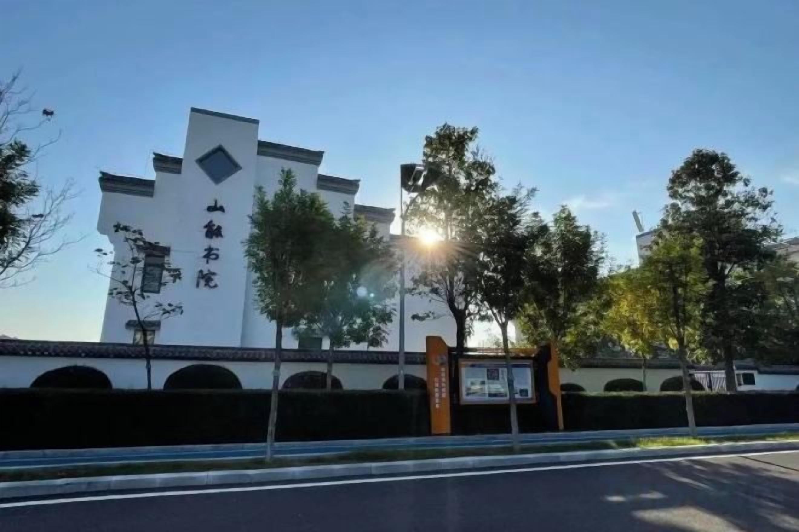 A building with a modern architectural design, featuring a prominent entrance and a series of arches along the facade.