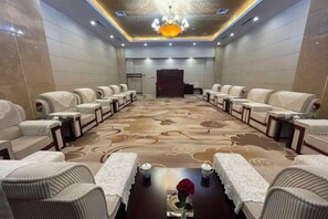 Una sala de conferencias con una larga mesa, sillas y piso alfombrado.
