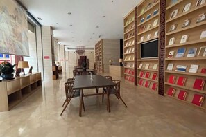 Une bibliothèque avec une longue table et des chaises, entourée d’étagères.