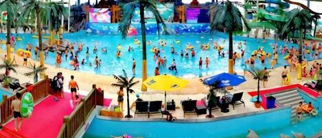 An indoor swimming pool with multiple lanes, slides, and a red carpeted area.