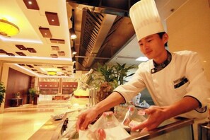 Een kok in een witte uniform met een hoge koksmuts bereidt eten in een goed verlichte keuken met moderne accenten.