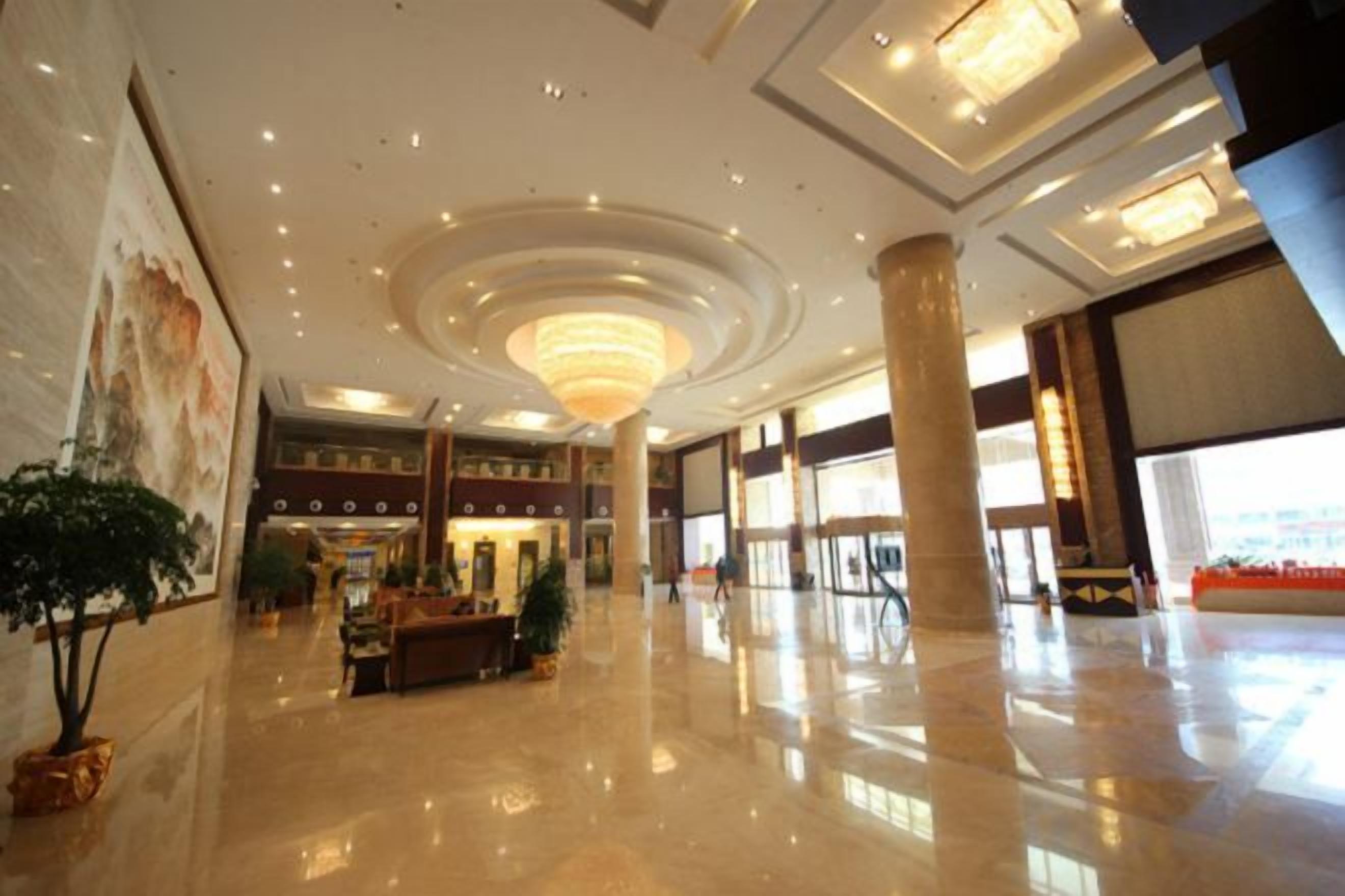 A spacious lobby with a high ceiling, large columns, and a reception desk.