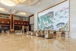 A spacious lobby with a large mural, multiple seating areas, and a modern chandelier. - Shandong Energy International Hotel (Tai'an)
