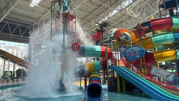 Un parc aquatique intérieur doté d’un toboggan aquatique, de nombreuses structures de jeux et d’une grande piscine.