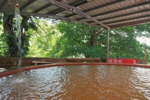 Ein überdachter Pool mit Holzdeck und einer roten Absperrung.