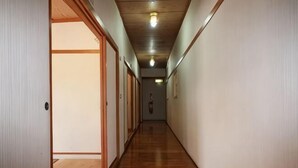 A corridor with wooden flooring, a wooden ceiling, and a light fixture. - Juei-Suei Hotspring (Hualien)