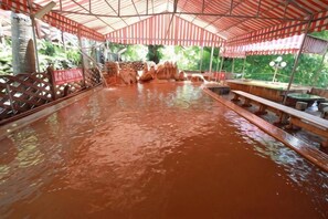Une piscine couverte avec des bancs et une clôture en bois.