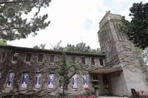 Un bâtiment doté d’une façade en pierre, de nombreuses fenêtres et d’une petite entrée.