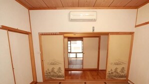 A traditional Japanese room with tatami flooring, sliding doors, and a ceiling-mounted air conditioner. - Juei-Suei Hotspring (Hualien)