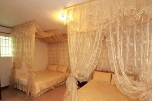 Ein Zimmer mit zwei Betten, jedes mit einem Baldachin ausgestattet.