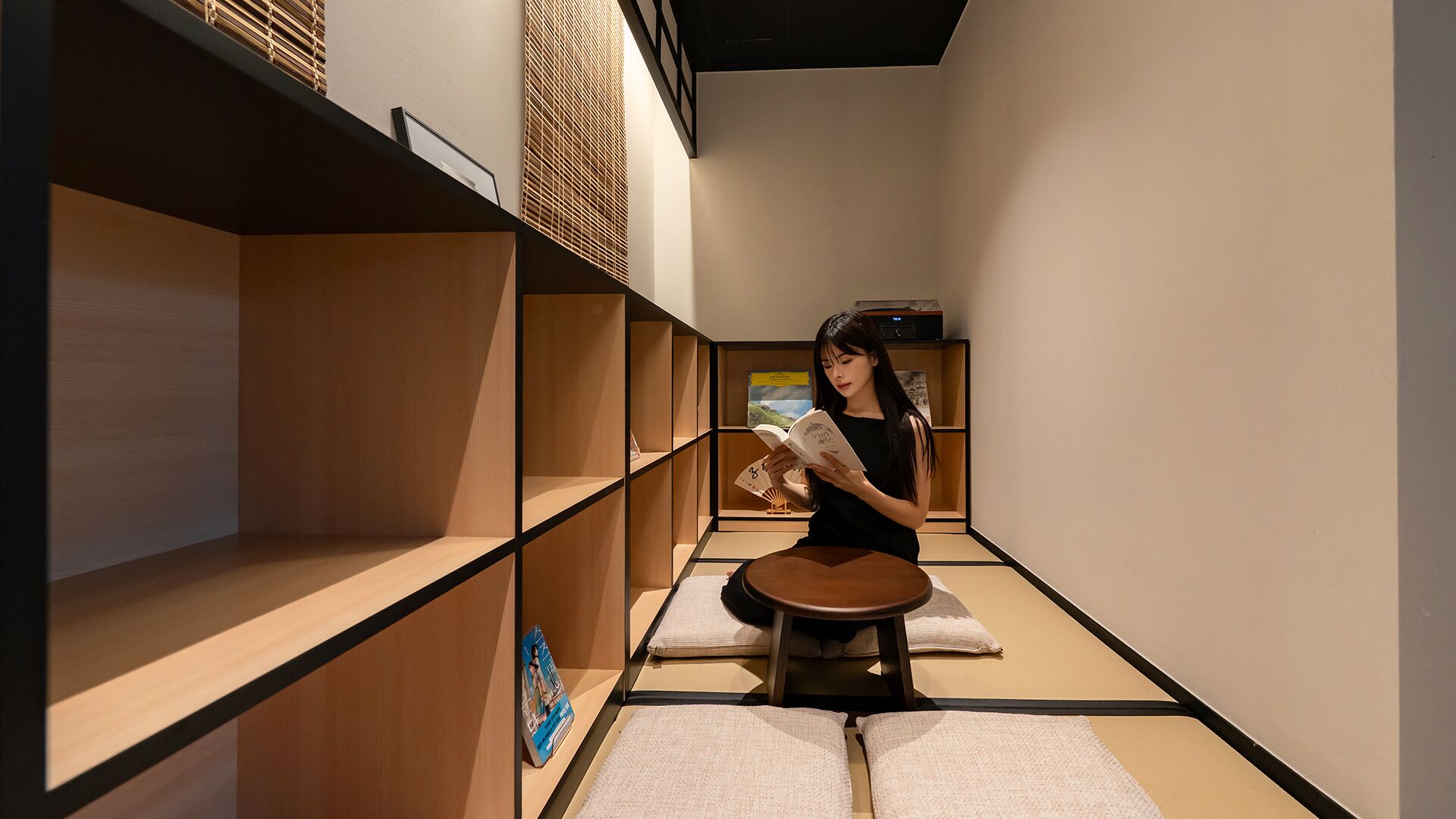 A minimalist room with wooden shelves, a tatami mat, and a small table.