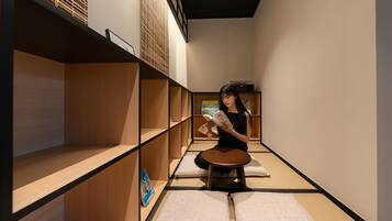 A minimalist room with wooden shelves, a tatami mat, and a small table.