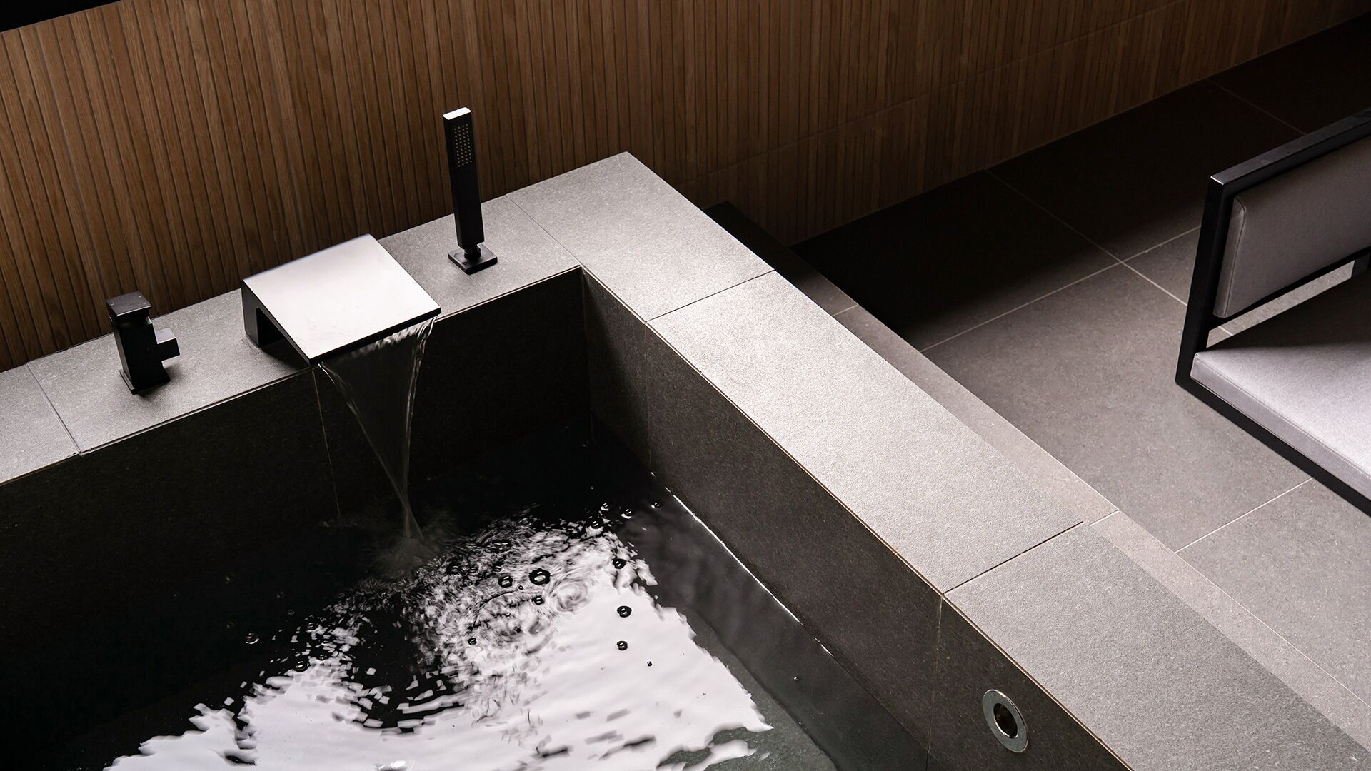 Un baño moderno con un lavamanos rectangular, dos llaves y un desagüe.