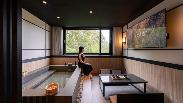 A modern interior with a large window, a wooden bench, a table with bowls, and a wall-mounted artwork. - Mitasuya Ryokan Hotel by Anook Gongju  (Gongju)
