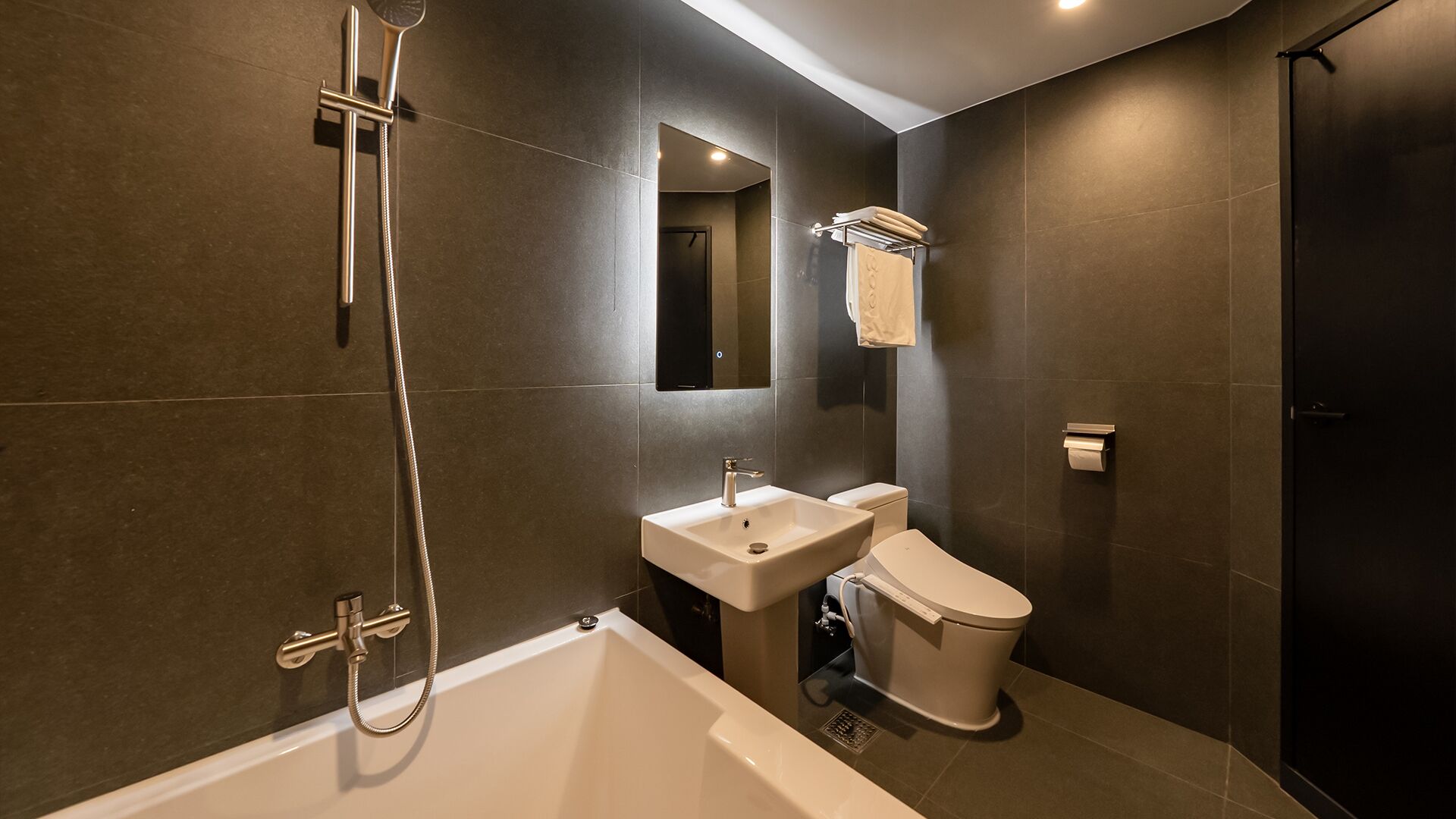 A modern bathroom with a bathtub, toilet, and sink.