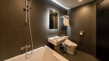 A modern bathroom with a bathtub, toilet, and sink.