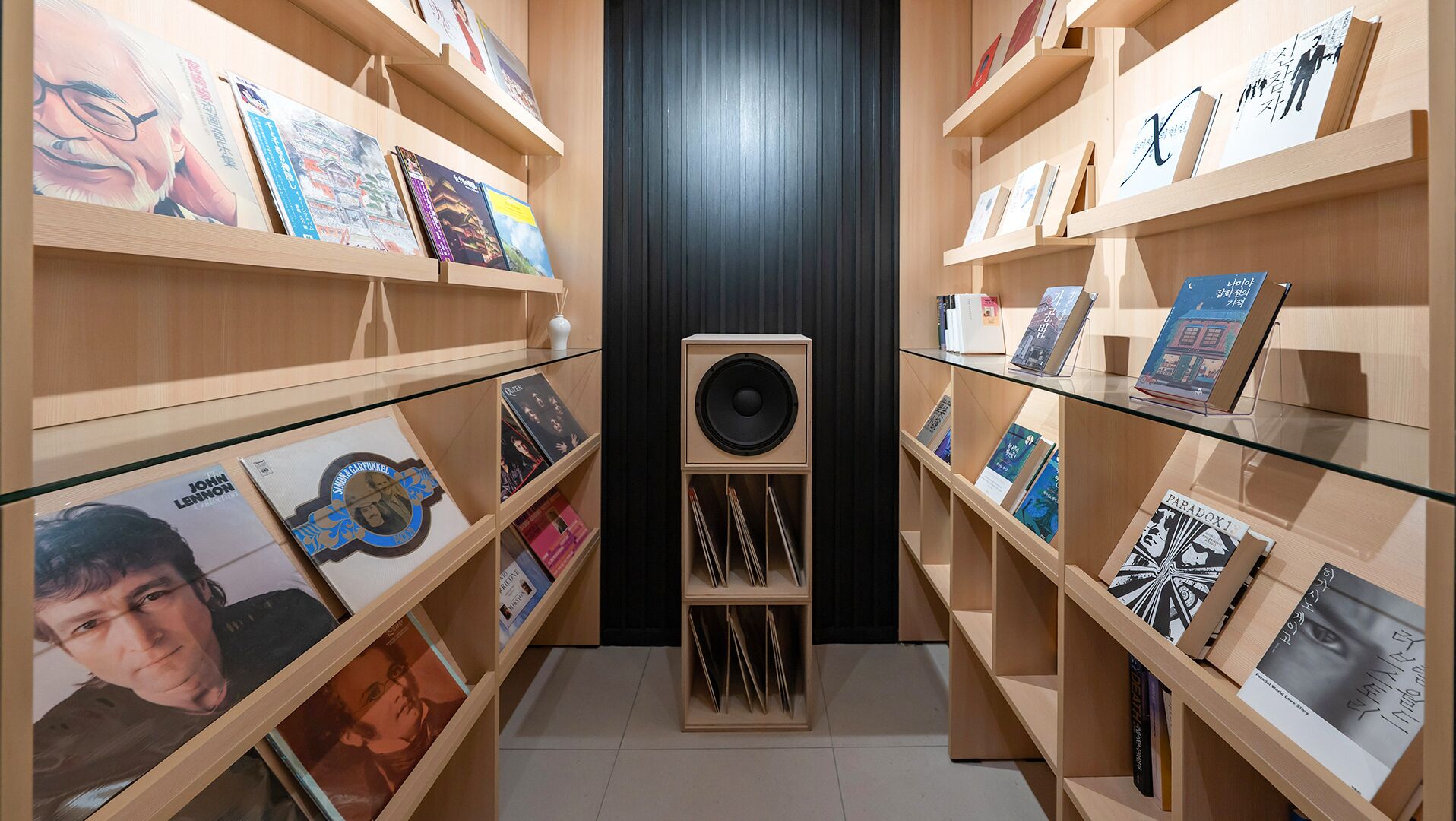 Uma livraria com prateleiras de madeira e um painel preto central.