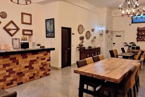 A restaurant with a wooden bar and a long dining table with chairs. - Summer Time Homestay (Chiayi City)