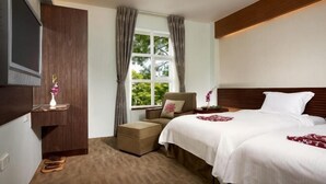 A hotel room with a bed, a chair, a TV, and a window with curtains. - Hwa Ger Hot Spring Hotel (Yilan)