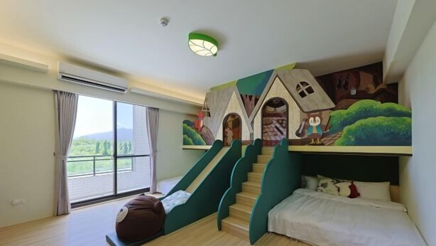 Ein Schlafzimmer mit einem Etagenbett, einer Treppe, einem großen Fenster und einem Wandgemälde.