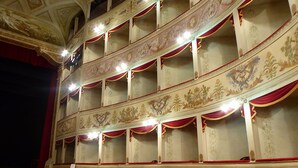 Teatteri, jossa on koristeelliset, kultakoristeiset katot ja punaiset verhot.