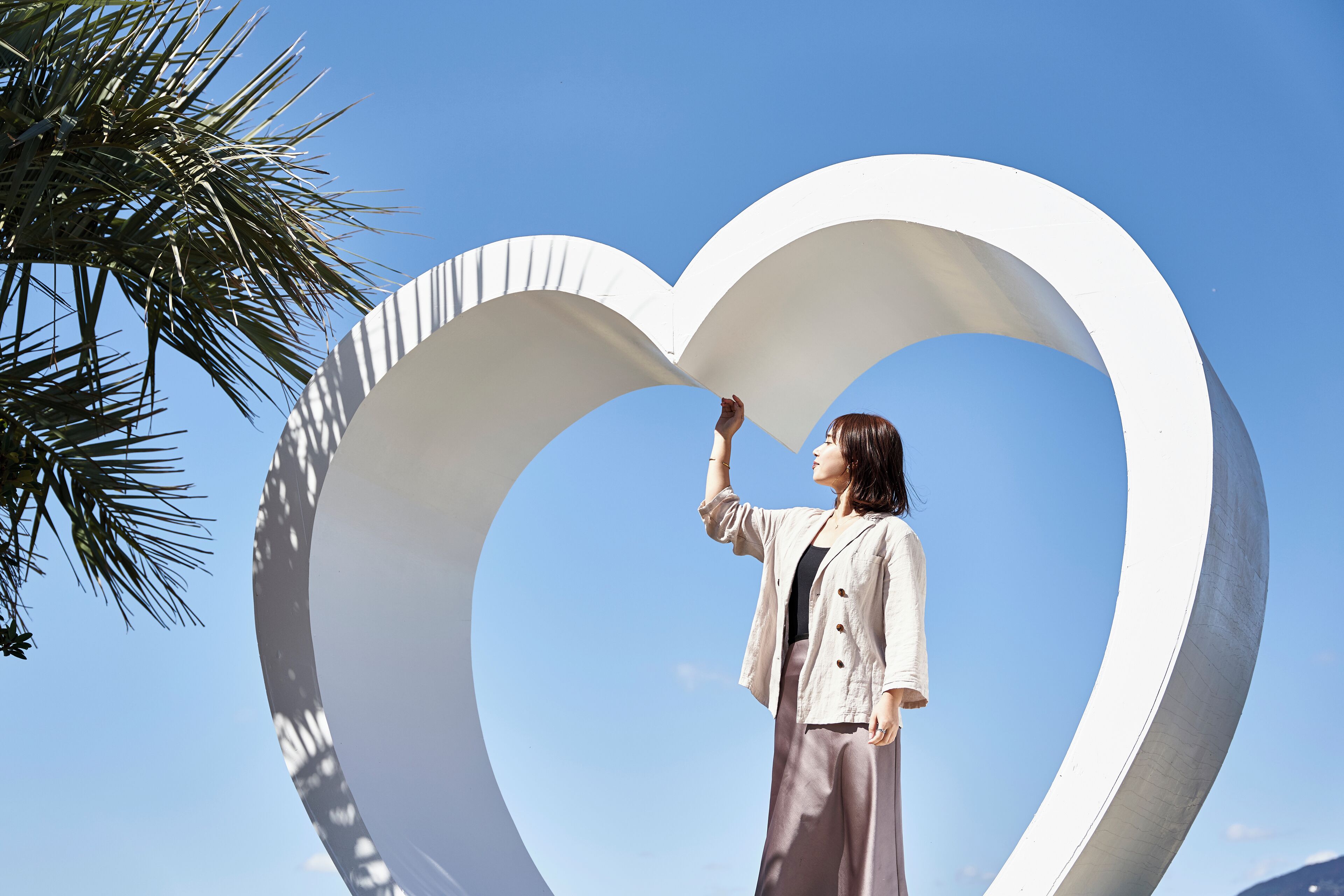 A person standing in front of a large white heart-shaped structure.