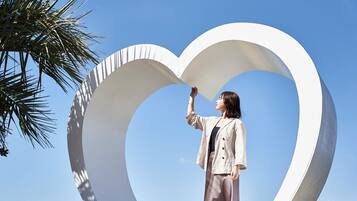 A person standing in front of a large white heart-shaped structure.