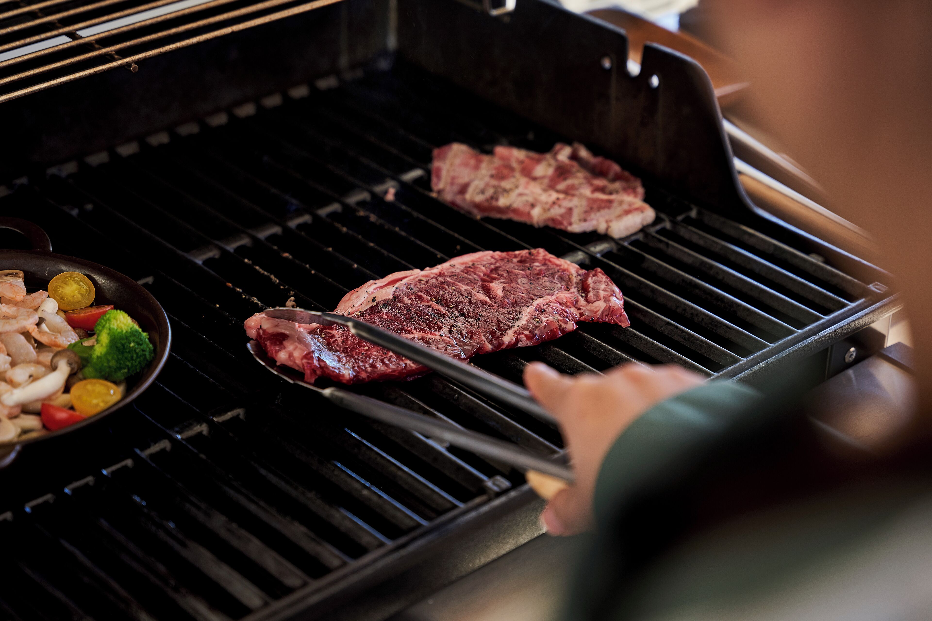A grill with two steaks being cooked.