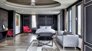 A modern bedroom with a bed, a sofa, a red chair, a small table, and a large window. - Lafika｜Dao Villa (Yilan)