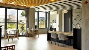 A modern dining area with a wooden ceiling, large windows, and a view of the outside. - Lafika｜Dao Villa (Yilan)