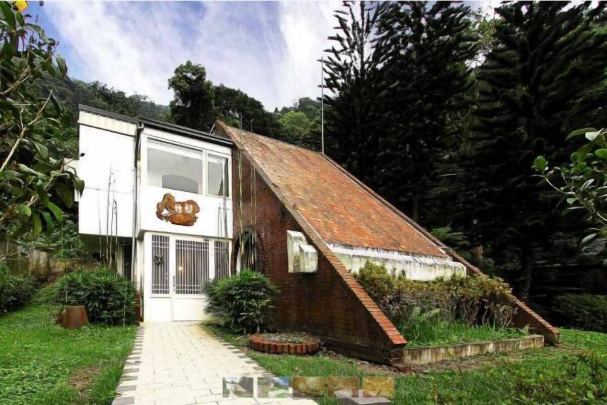 A house with a sloped roof, a white exterior, and a brick section.