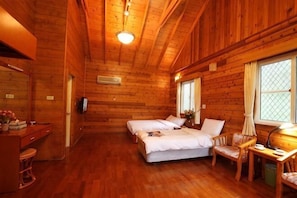 A wooden cabin room with two beds, a desk, and a chair. - Sun Moon Lake Youth Activity Center (Nantou)