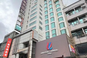Un bâtiment sur lequel on peut lire l’inscription « UNIVERSAL CARNIVAL CINEMAS » et une autre inscription indiquant « UNIVERSAL CARNIVAL CITY ».