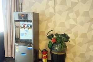 Un mini-bar équipé d’un réfrigérateur et agrémenté d’une plante en pot.