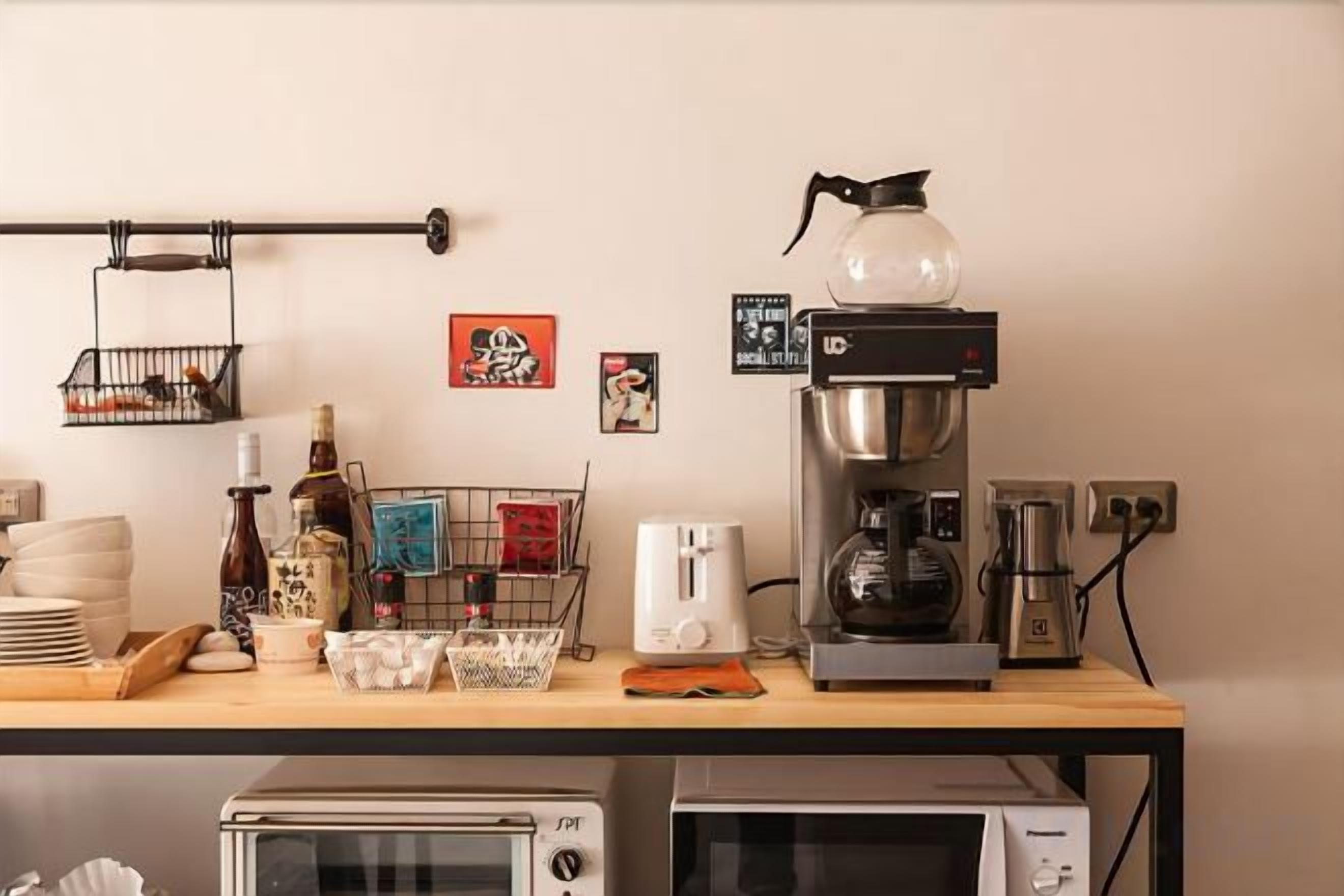 A kitchenette with a coffee maker, toaster, and microwave.