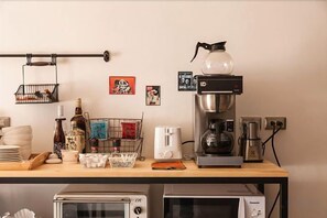 A kitchenette with a coffee maker, toaster, and microwave. - Mini Voyage Hostel (Hualien)