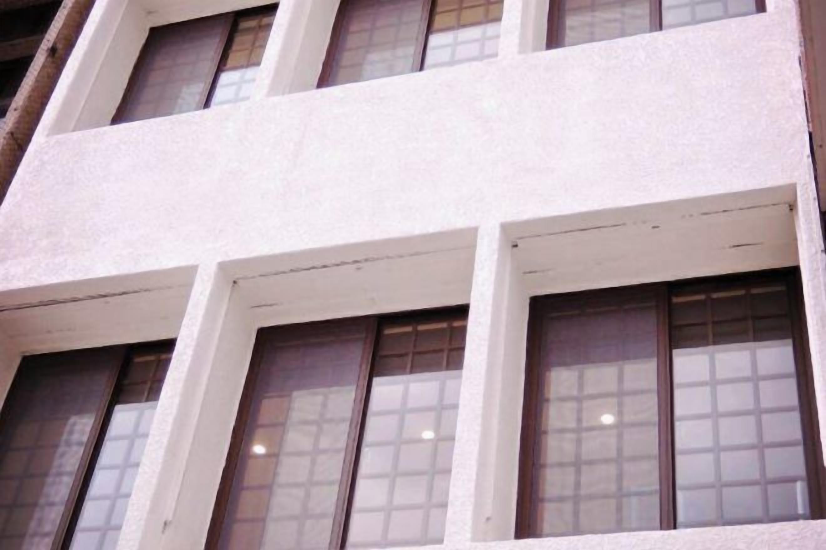 A building facade with multiple windows and a textured wall.