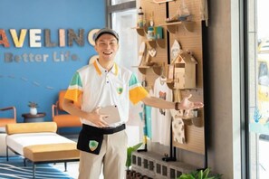 A hotel room with a bed, a desk, and a wall with a sign. - Fullon Poshtel Penghu (Penghu)