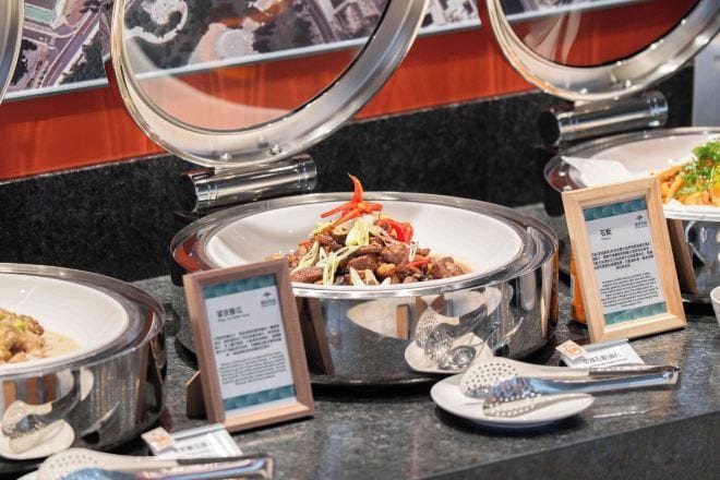A buffet setup with multiple dishes and serving utensils.