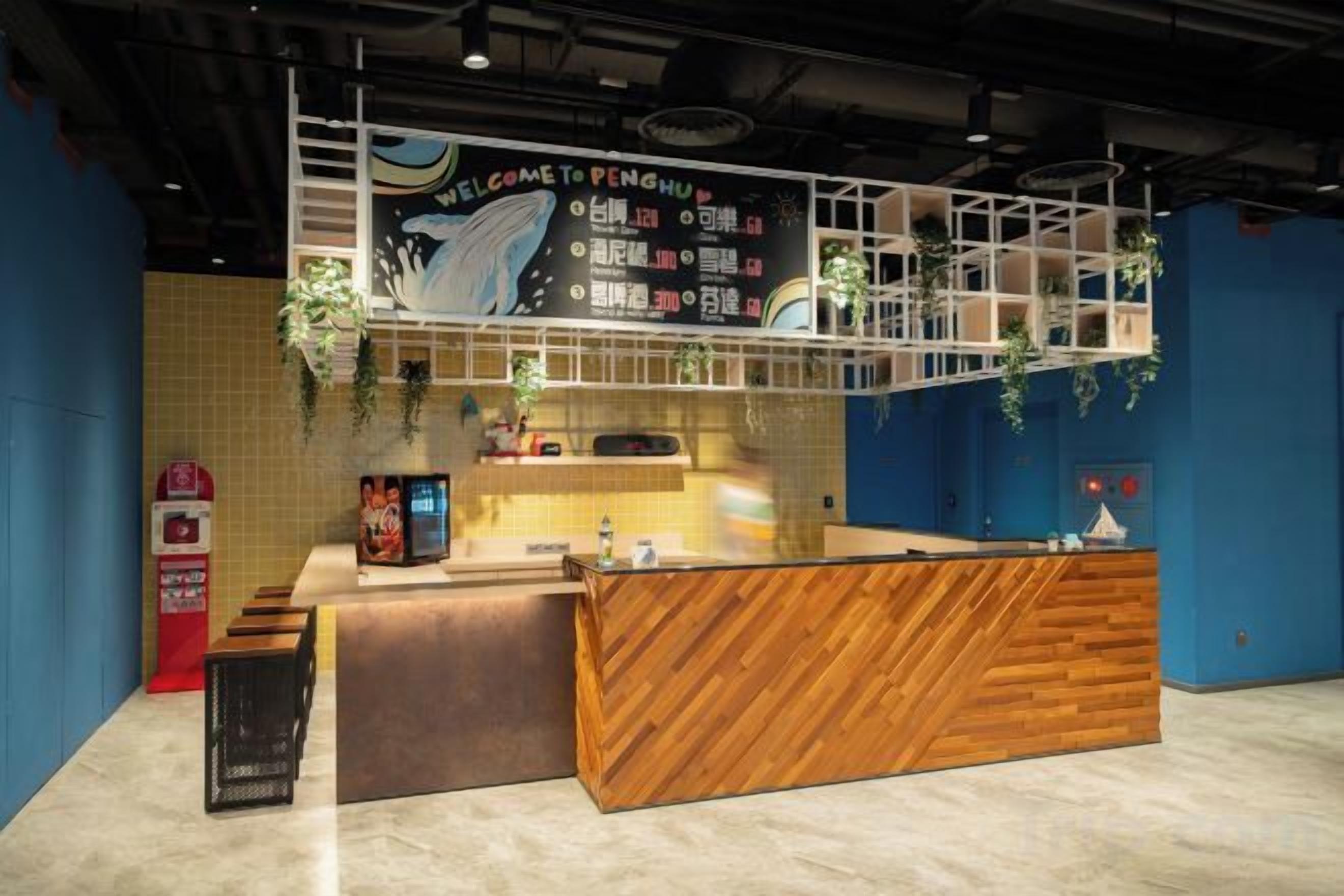A reception area with a wooden counter, a blue wall, and a sign above welcoming visitors.