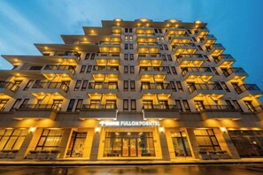 A multi-story hotel with balconies, a prominent entrance, and illuminated signage. - Fullon Poshtel Penghu (Penghu)