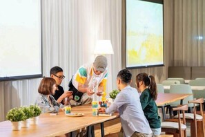 A meeting room with a long table, chairs, a projector screen, and a lamp. - Fullon Poshtel Penghu (Penghu)