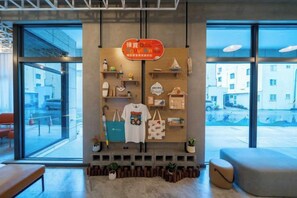 A retail display with various bags and a T-shirt, a bench, and a seating area with potted plants. - Fullon Poshtel Penghu (Penghu)