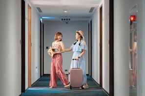 A hotel corridor with a blue carpet, doors on both sides, and a ceiling light fixture. - Fullon Poshtel Penghu (Penghu)