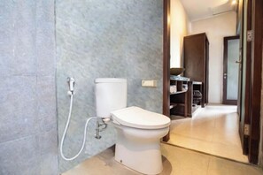 A modern bathroom with a toilet, a shower, and a mirror. - Me Villa Pererenan (Bali)