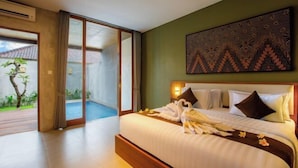 Quarto de hotel com uma cama grande, porta de vidro que dá para uma piscina e uma obra de arte pendurada na parede.