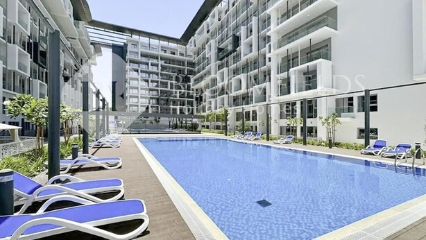 A modern hotel with a central swimming pool, sun loungers, and a multi-story building with balconies. - Bloomfeilds Central STU  OASIS Masdar (Abu Dhabi)