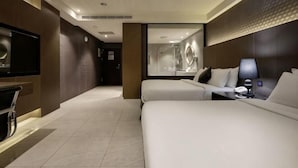 A hotel room with two beds, a TV, a desk with a lamp, and a large mirror. - Tsaotun Boutique Hotel (Nantou)